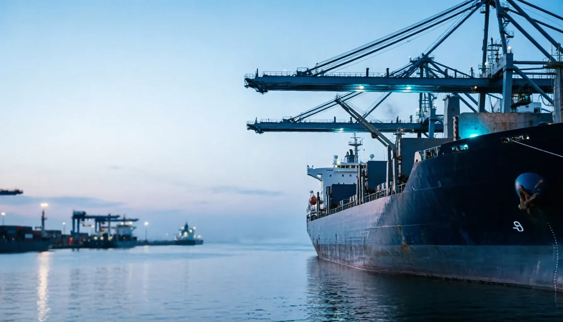 Cargo ship at port with cranes at golden hour